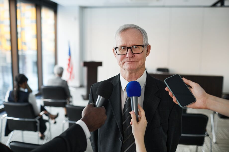Digital PR and media outreach — a spokesperson being interviewed by journalists with microphones